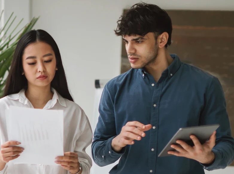 Young man and woman discussing how they can support an executive team.
