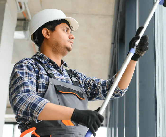 Man cleaning the windows at a facility as part of the service that Executive Concierges offers. 