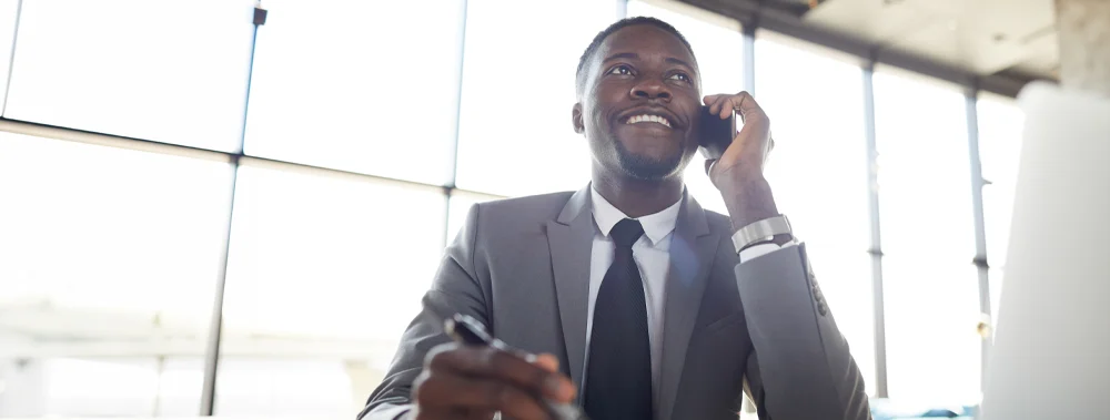 A young executive is on the phone making a call to order a service from Executives Concierge